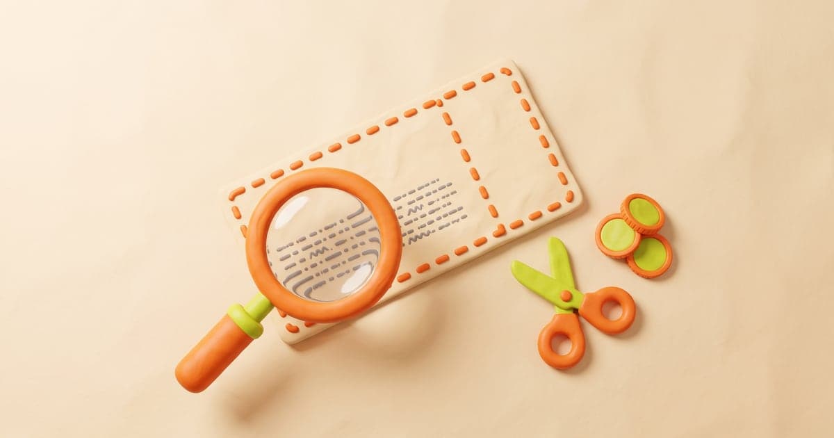 An oversized paper coupon under a magnifying glass that enlarges its fine print, beside scissors and a small stack of coins.